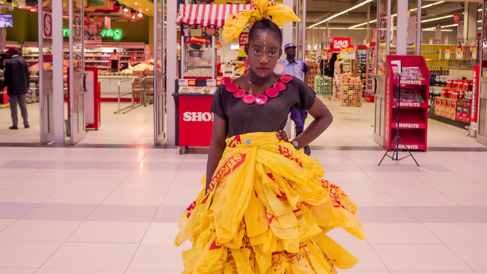 Girl posing outside mall in recycled bag dress.