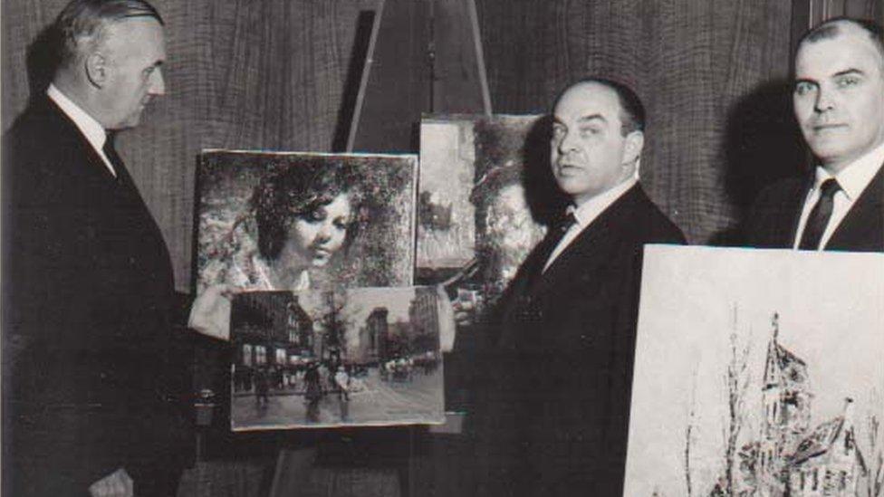 FBI agents standing next to stolen paintings that have been recovered