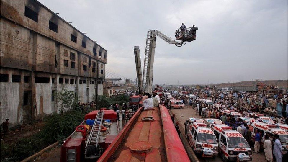 Ambulances and fire brigade vehicles outside a building, after a fire at a garment factory in Karachi September 12, 2012.