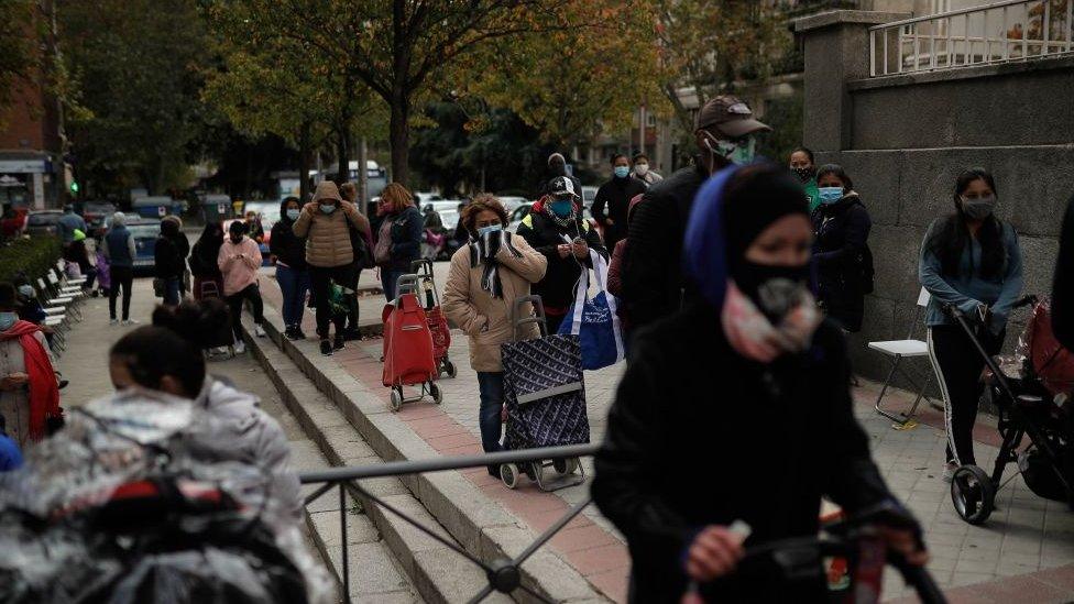 People wait in line to receive food donation in Madrid, Spain on November 04, 2020