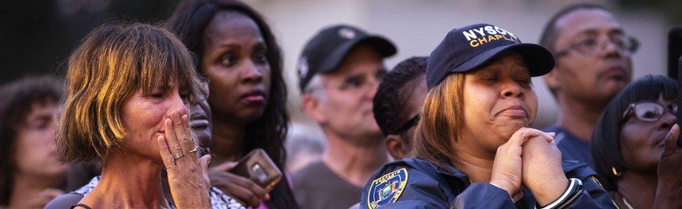 People attend a vigil for the victims of the recent mass shootings