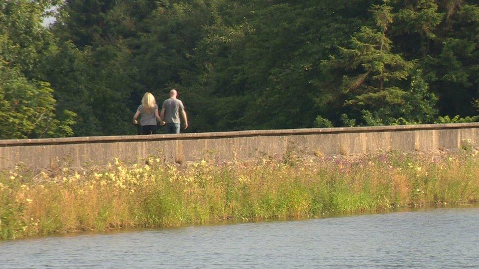 A couple walking along a river