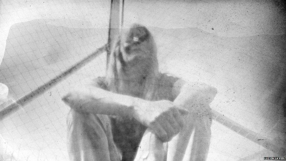 A pinhole photograph shows a woman