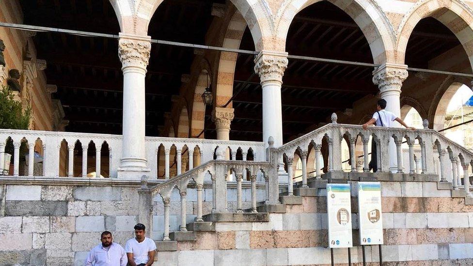 Migrants under the Venetian loggia in Udine