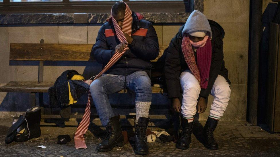 Migrants from Guinea don winter shoes and clothes donated by a charity organisation in Bardonecchia, Italy, 13 January 2018