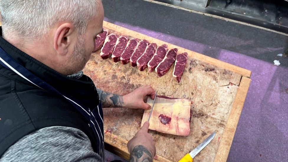 A butcher cuts some meat