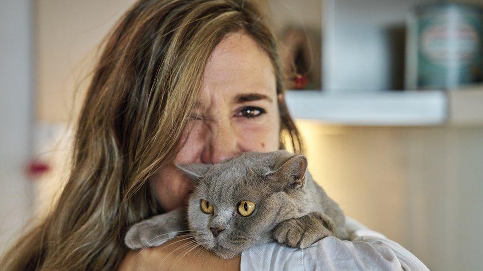 Woman hugs cat