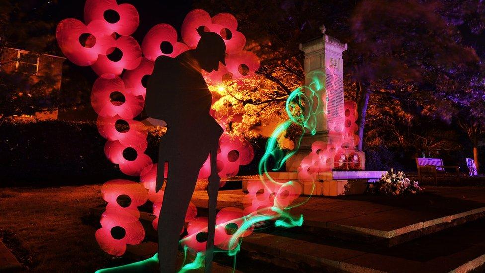 Walton-on-the-Naze war memorial photographed at night with lighting techniques to add poppies and light trails