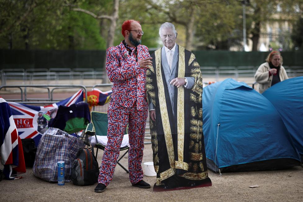 A man poses with a cut-out of King Charles on the Mall ahead of the Coronation.