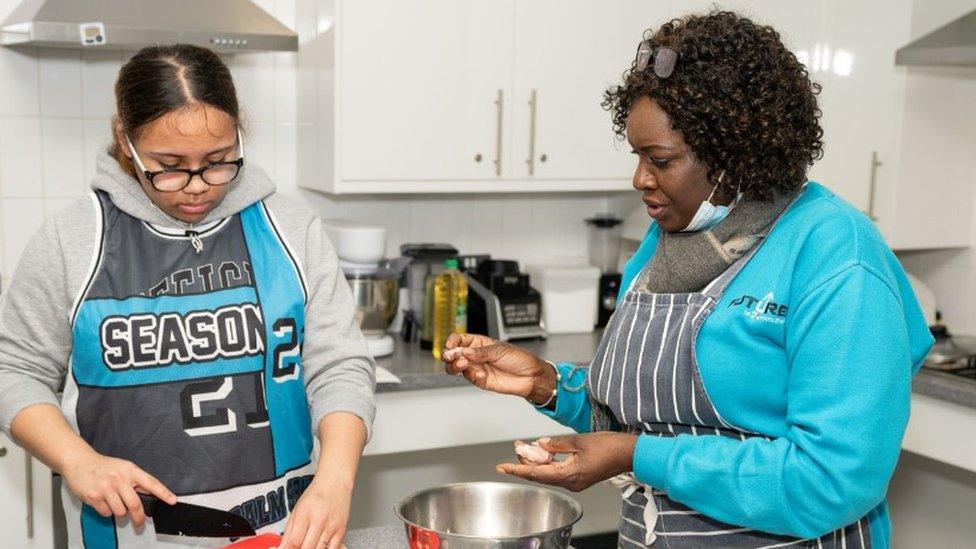 Teenage girl and woman preparing food on a kitchen worktop