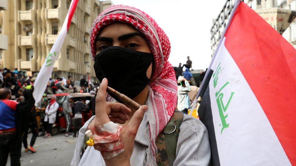 An Iraqi anti-government protesters holds up live ammunition allegedly used by security forces in al-Khilani Square, Baghdad (1 March 2020)