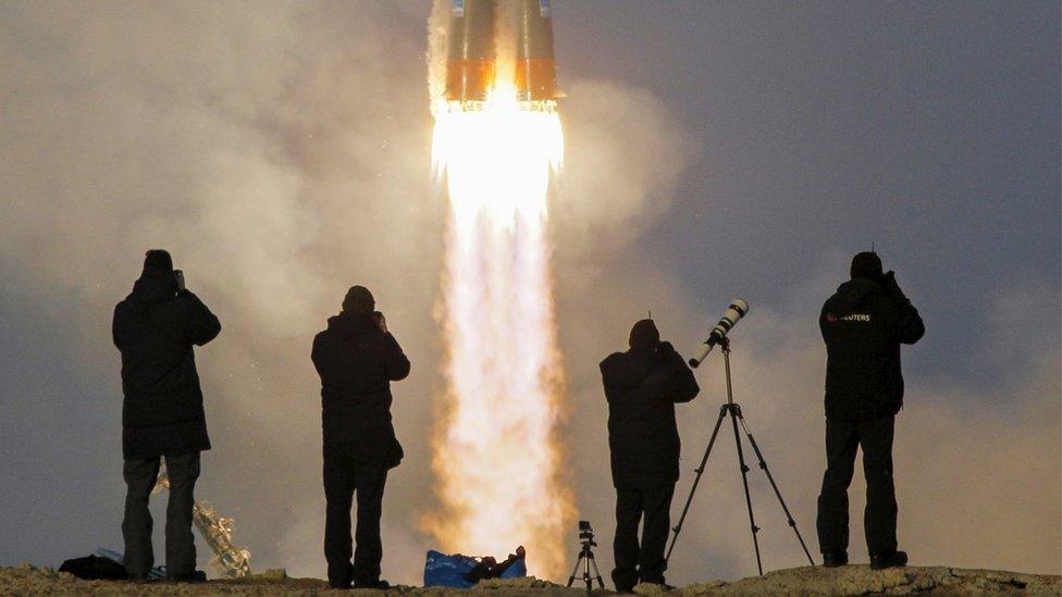 Photographers take pictures as the Soyuz TMA-19M spacecraft