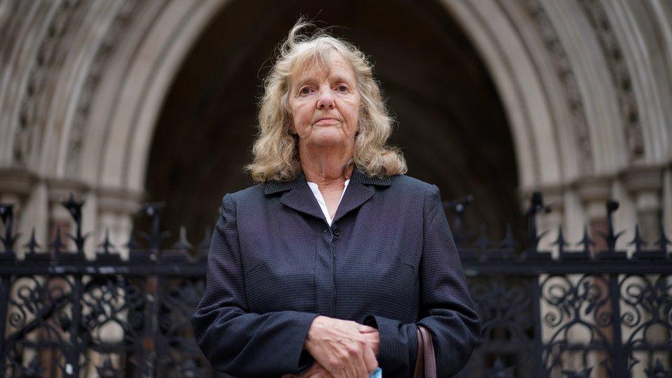 A woman stands outside the court