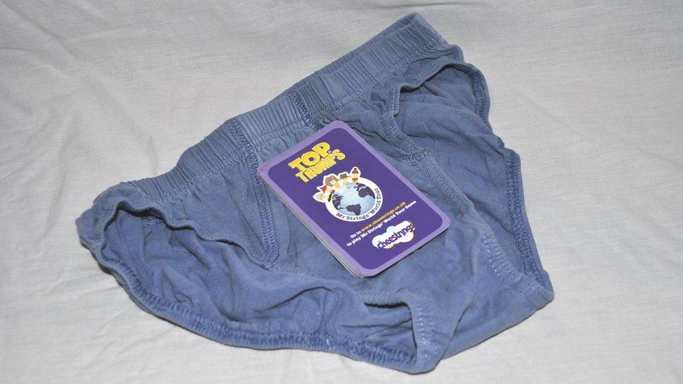 A picture of a pack of cards on top of a pair of underpants