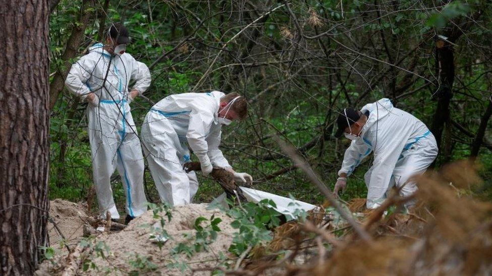 Forensic experts work at a site where a person was allegedly killed and buried by Russian troops in the Bucha district near Kyiv, Ukraine. Photo: June 2022