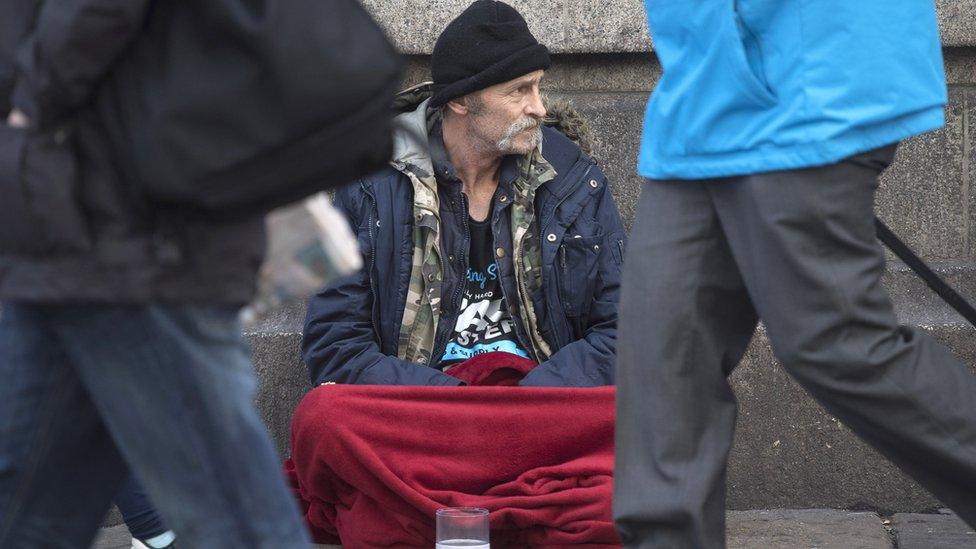 A homeless person outside Victoria Station in London