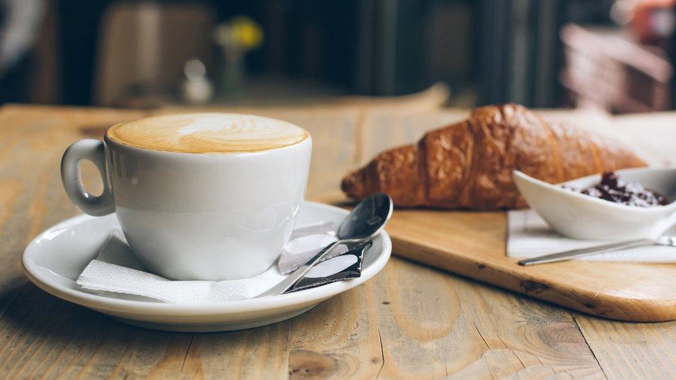 A coffee and croissant at a cafe