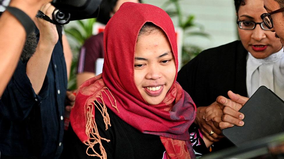 Siti Aisyah surrounded by reporters