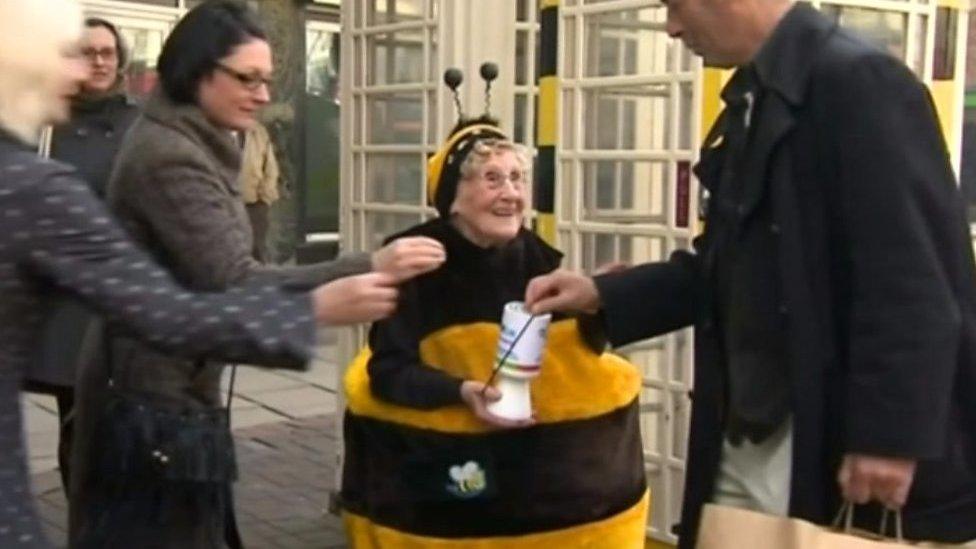 Woman collecting money for charity dressed in a bee costume