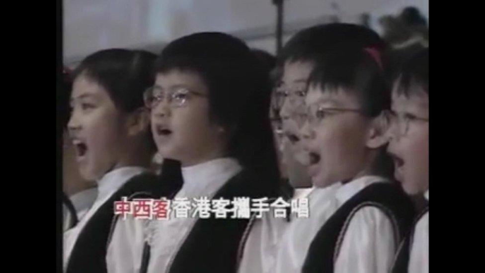 Still of Yip's Children's Choir performing in the handover ceremony