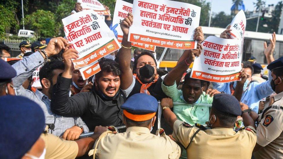 Activists and supporters of Bharatiya Janata Party (BJP) hold placards as they scuffle with police during a protest.