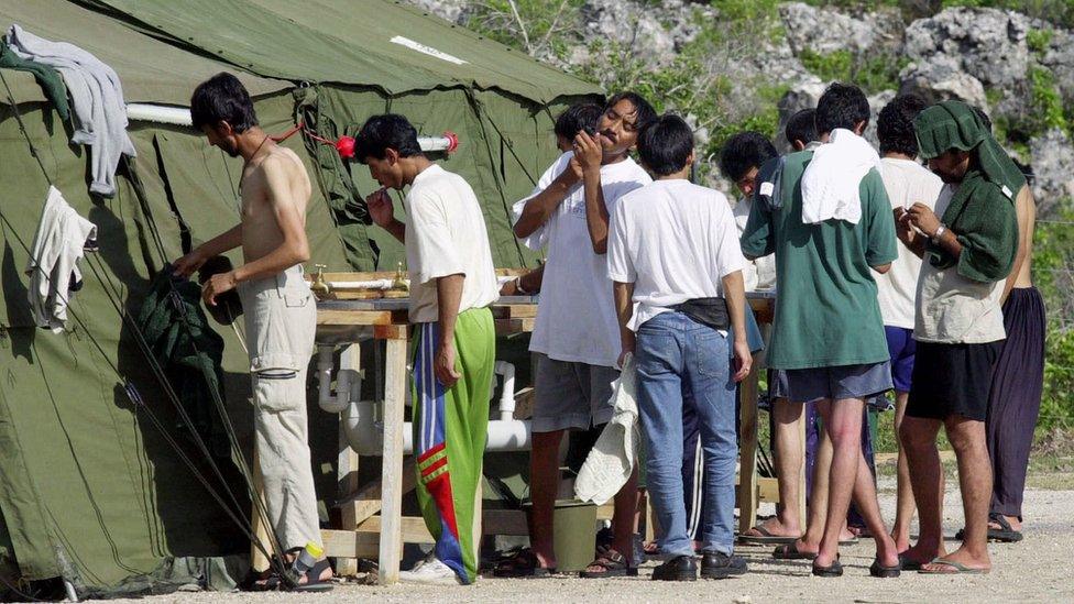 Men wash at a refugee camp on the Island of Nauru, 21 September 2001