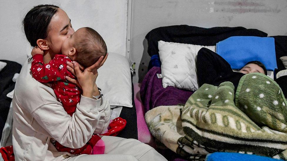 A young mother comforts her infant in a temporary shelter for Ukrainian refugees, located near the Polish-Ukrainian border in a former shopping center in Przemysl, Poland, on 8 March 2022