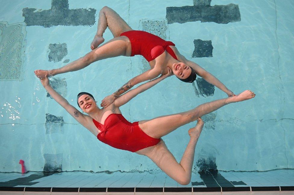 Members of Aquabatix, a synchronised swimming team practice at a swimming pool