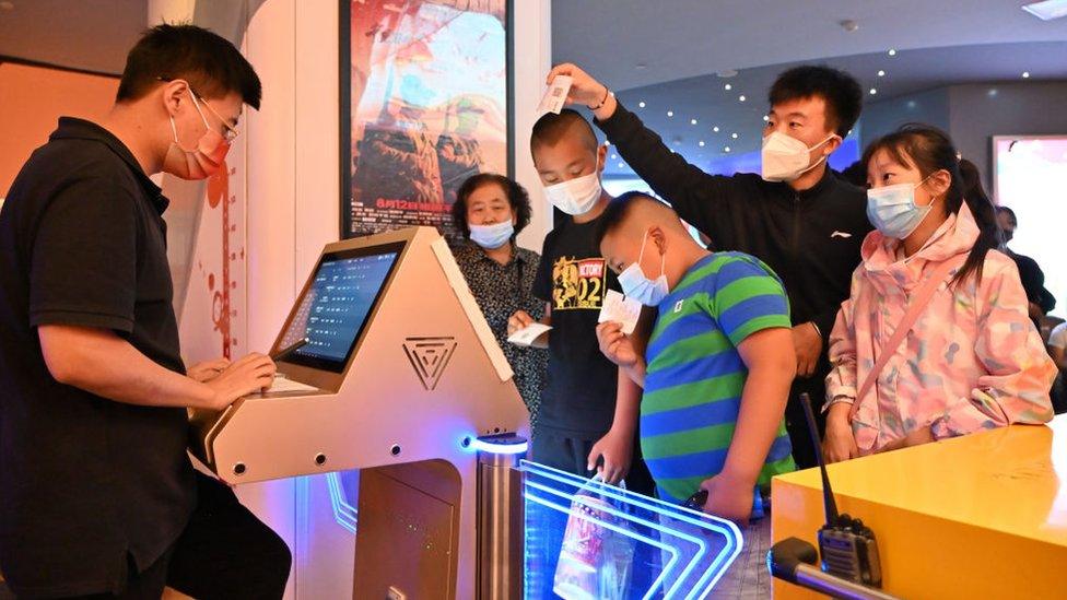 Customers wait to enter the screening hall of a cinema on China's National Day on October 1, 2021