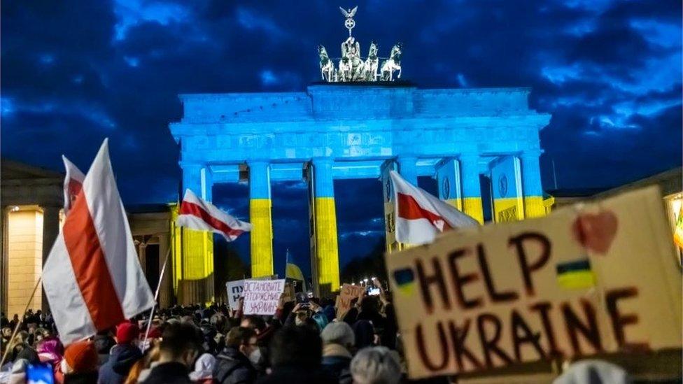 People protest in front of the Brandenburg gate in Berlin, Germany against the invasion