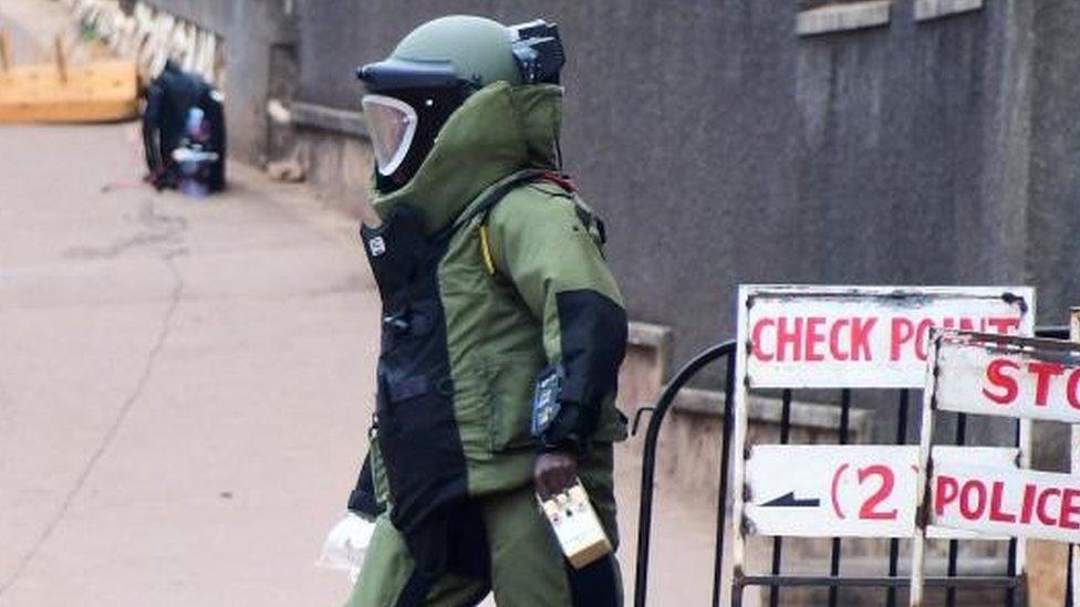 A bomb disposal expert dressed in his protective suit lays a cable as he prepares a controlled detonation of an explosive device outside a Pentecostal church, Lubaga Miracle Centre, in the Lubaga suburb of south Kampala, Uganda September 3, 2023.