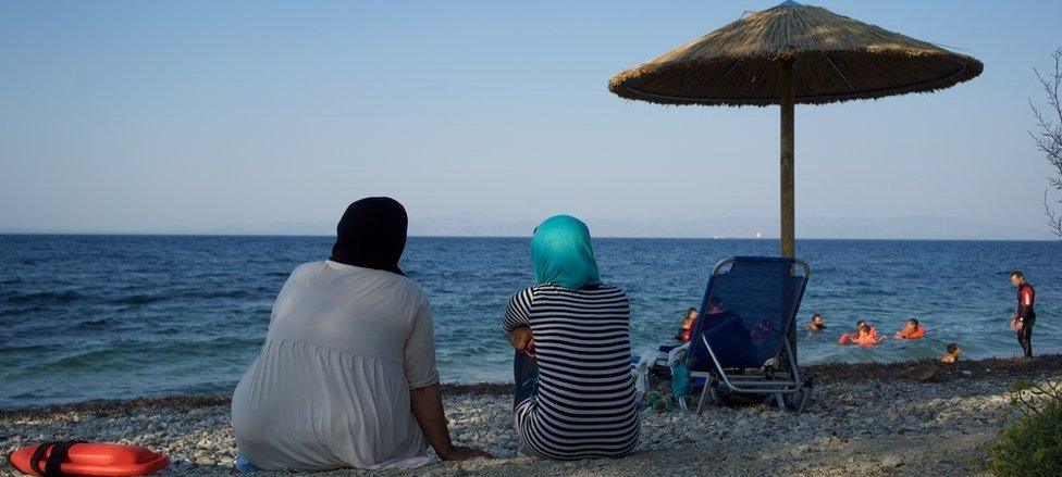 Women look on from the beach