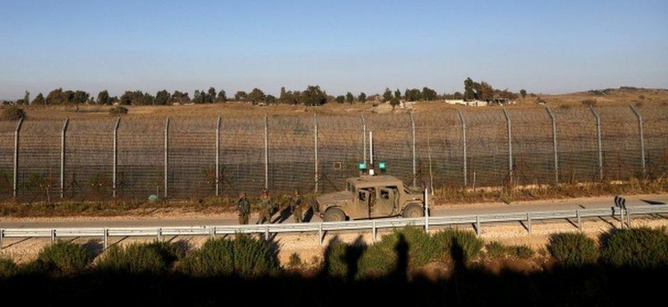 Israeli soldiers patrol the ceasefire line between Israel and Syria, as seen from the Israeli-occupied Golan Heights