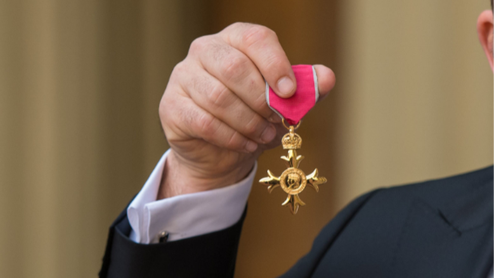 Man holding MBE medal