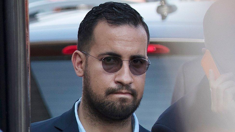 This file photo taken on July 16, 2018 shows Elysee senior security officer Alexandre Benalla standing next to a bus and the plane transporting the France"s national football team at the Roissy-Charles de Gaulle airport on the outskirts of Paris