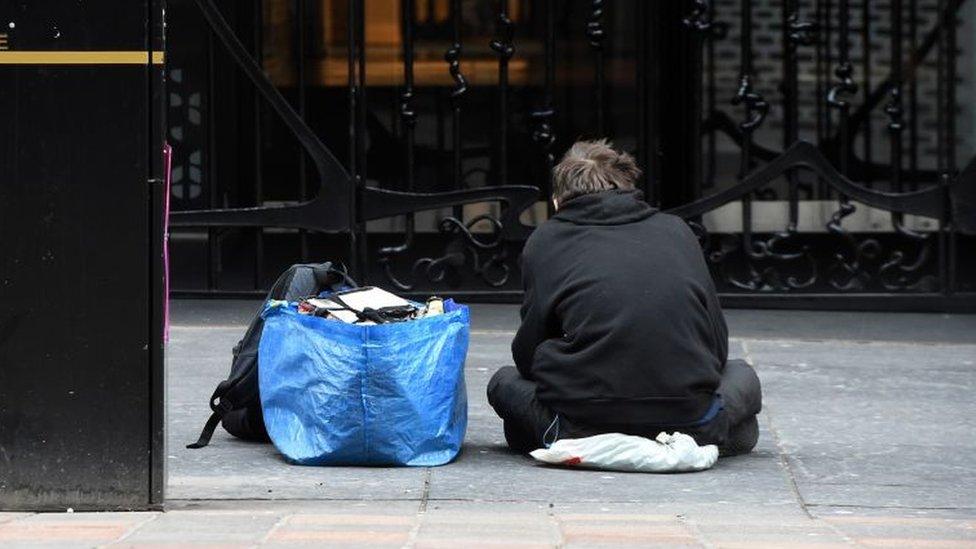 A homeless person sits in a Glasgow city centre street on March 27, 2020