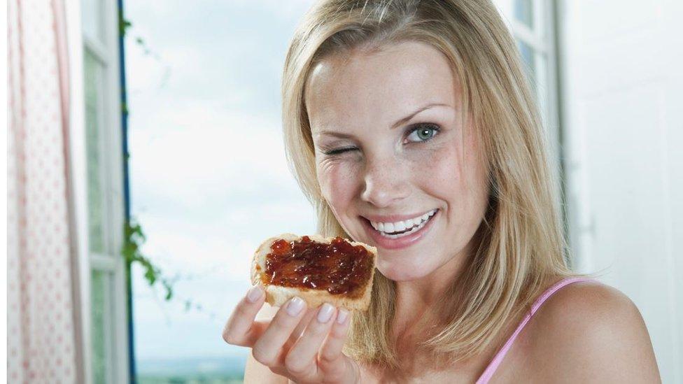 Woman eating jam sandwich