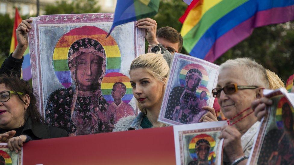 Demonstrators wave abundant copies of Ms Podlesna's poster alongside rainbow flags