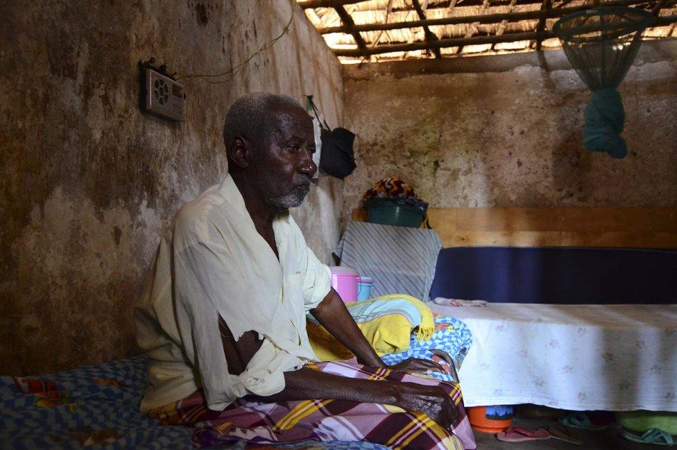 A man sits on his bed