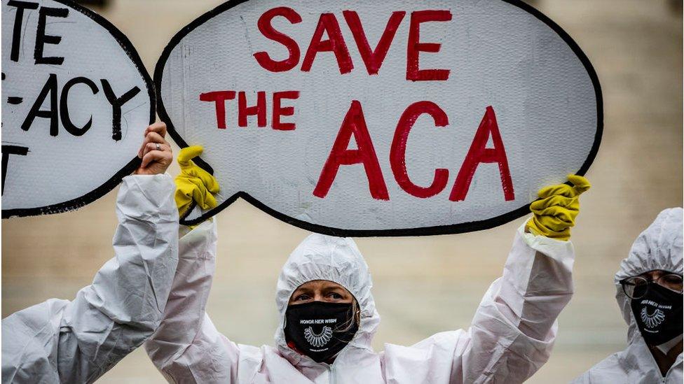 Protesters who support Obamacare stand outside the Supreme Court during the hearing