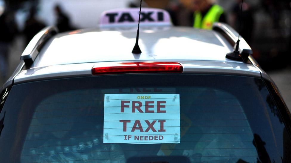 A taxi advertises its services for free in Albert Square in Manchester