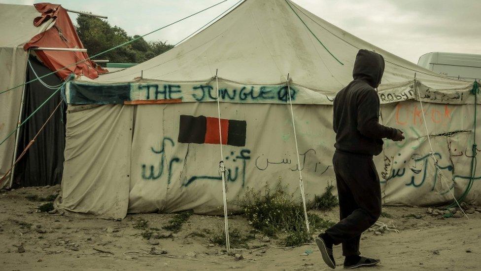 A refugee walks in the Calais migrant camp