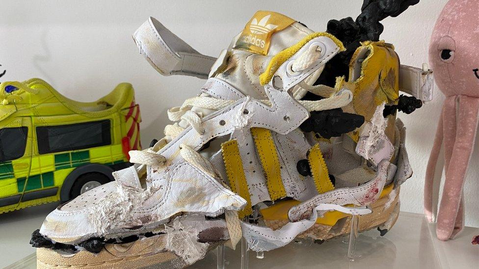 A yellow Adidas trainer which has been redesigned and taken apart