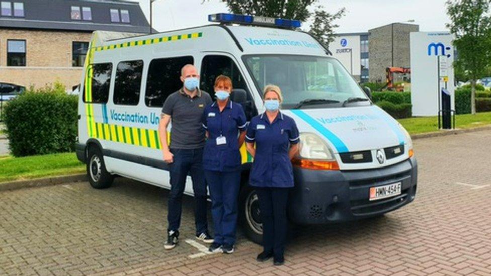 Staff standing in front of vaccination bus