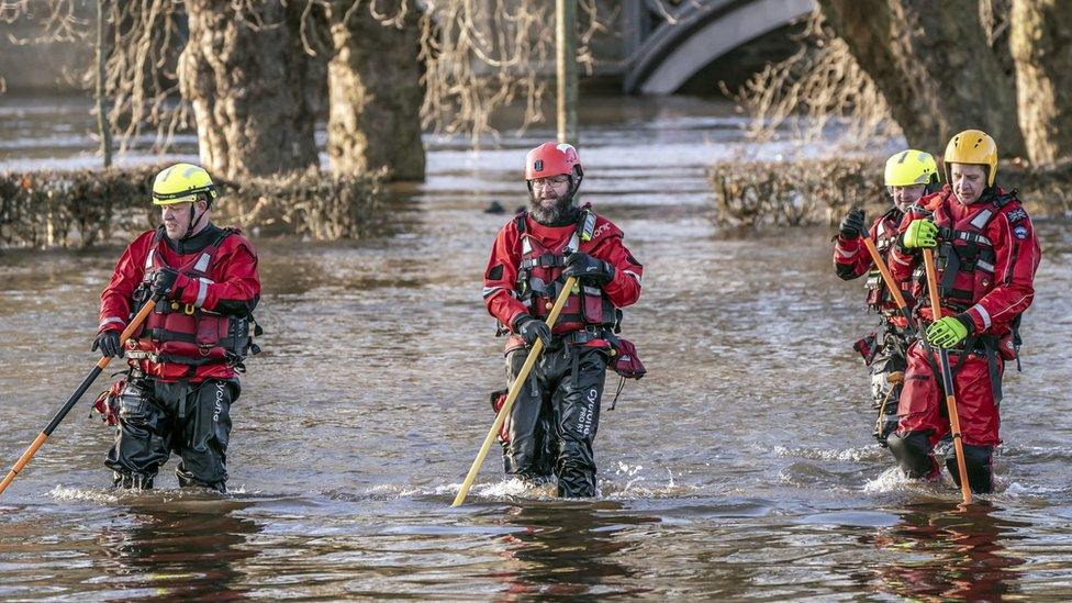 Rescue workers wade through York after the River Ouse burst its banks