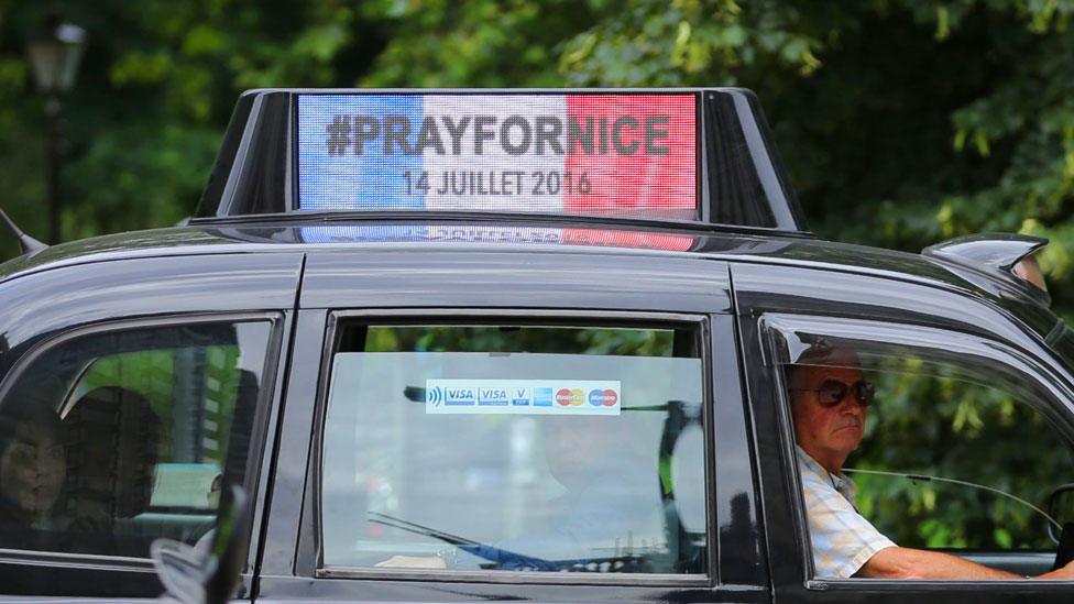 A London taxi carries a sign "Pray for Nice"