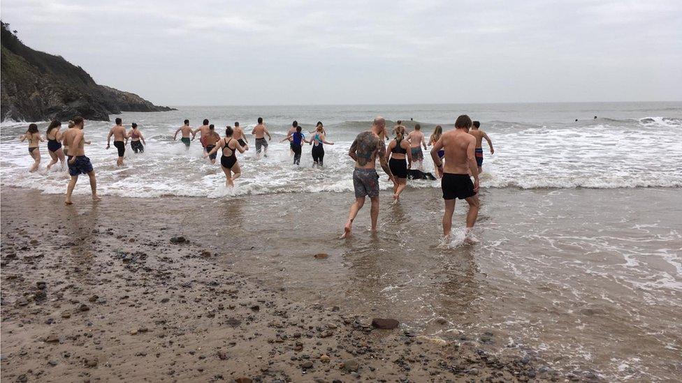 People running into the sea