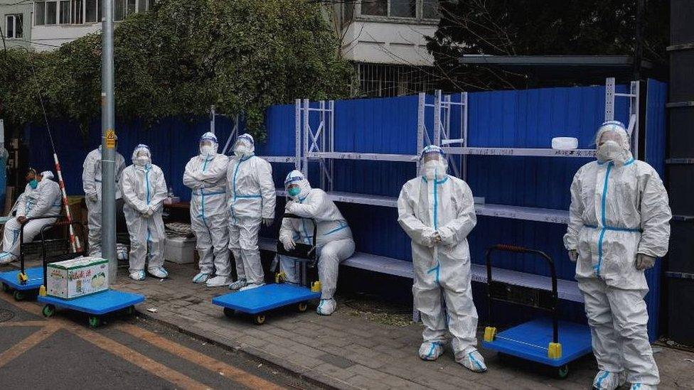 Workers in hazmat suits outside residential complex in Beijing