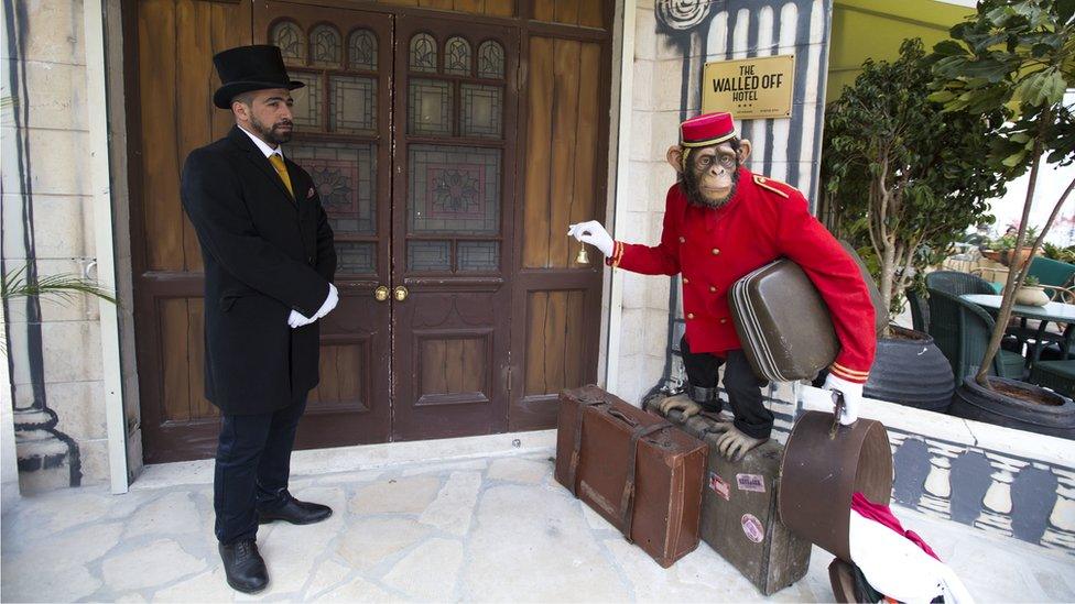 Doorman stands at the entrance of the "The Walled Off Hotel" in the West Bank city of Bethlehem, Friday, March 3, 2017.