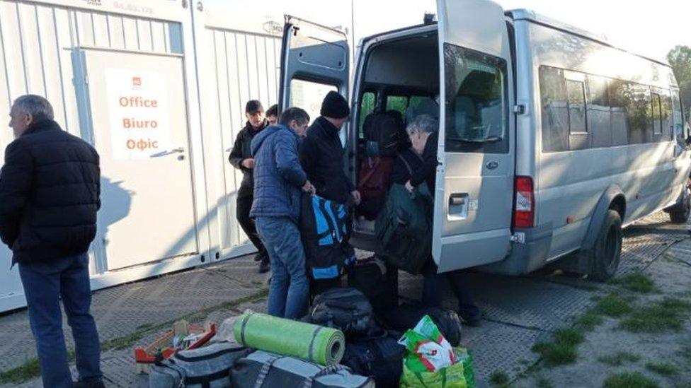 Group loading luggage onto a bus